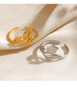 Macro shot of 18K gold and silver tulip rings on a beige silk background