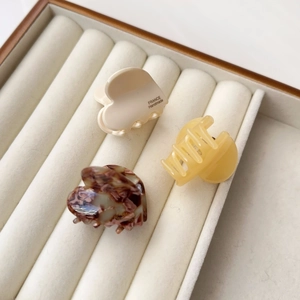 Detailansicht von drei kleinen Herz-Haarklammern aus Acetat in Creme, Gelb und Schildpatt