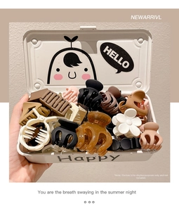 Assorted resin hair clips in matte brown and beige inside a small metal gift box