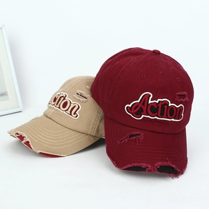 Close-up of distressed vintage baseball caps with embroidered Action letters and torn details