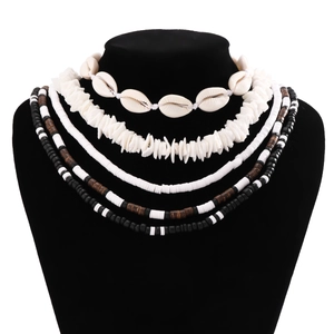 Detail of bohemian layered necklace with white shells, clay discs and wood beads