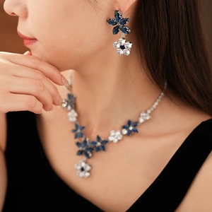 Detail of floral jewelry set featuring blue crystals on a model for a stylish look