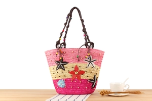 Détail du sac tressé rose et beige avec broderie étoile de mer et perles colorées