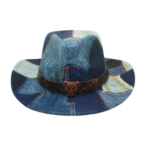 Detail of vintage denim patchwork cowboy hat with leather band and bronze leopard emblem