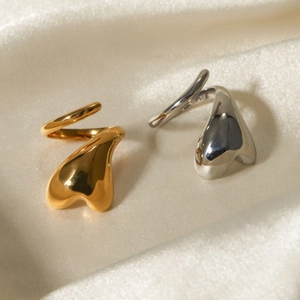 18K gold and silver stainless steel rings with fluid heart design on white silk satin