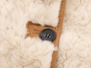 Detailed macro view of cream fleece jacket with brown placket and premium button stitching
