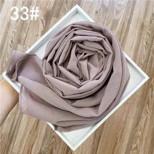 Détail d'une écharpe en mousseline rose grisâtre avec dorure, en forme de fleur