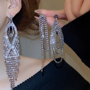 Macro detail of long silver fringe earrings featuring sparkling lavender crystal teardrops