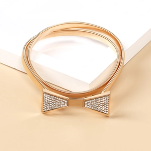 Detail eines goldenen elastischen Metallgürtels mit glitzernder Schleifenschnalle