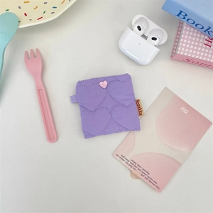 Detail of purple heart quilted earphone pouch with pink button and soft nylon texture