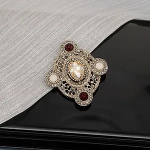 Macro detail of Baroque vintage brooch featuring micro-pave diamonds and oval crystal