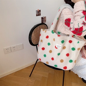 Detail of white plush tote bag with colorful polka dots held on a wicker chair background