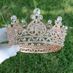 Elegant rose gold bridal crown with sparkling crystals shown against a green lawn background