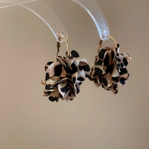 Detail of leopard print fabric flower drop earrings with golden hook earring findings