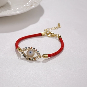 Detailed shot of red braided Evil Eye bracelet with colorful zircons and adjustable clasp