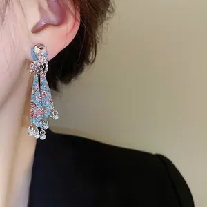 Elegant rhinestone tassel drop earrings with pink and blue stones on model
