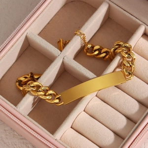 Close-up of 18K gold plated Cuban link bracelet with a rectangular plate in a pink box