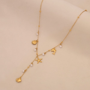 Close-up of gold ocean-themed necklace with pearl, starfish, and dolphin pendants