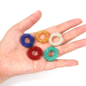 Detailed view of colorful metal spring finger massage rings in gold, silver, red, and blue