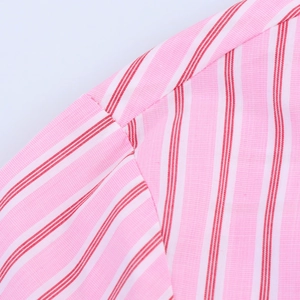Close-up of pink and red striped cotton fabric showing shoulder stitching and texture