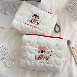 Quilted makeup bag with dog embroidery, heart patterns and a red zipper detail