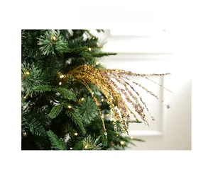 Close-up of sparkling gold and champagne sequin spray branches on a lit Christmas tree
