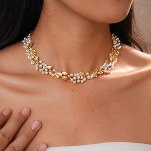 Detail showing vintage gold leaf design and white pearls on an elegant necklace