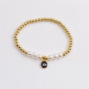 Bracelet bohème en perles dorées avec perles blanches et pendentif œil maléfique