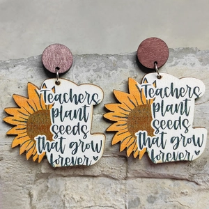 Wooden sunflower earrings with engraved teacher appreciation quote on a stone background