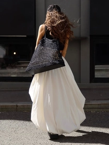 Jupe bouffante minimaliste en coton blanc pour femme avec un sac cabas noir tressé