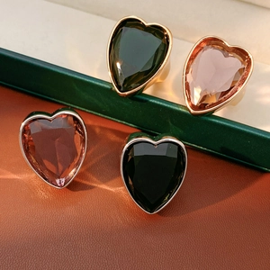 Macro detail of heart-shaped zircon rings in multiple colors on luxury leather