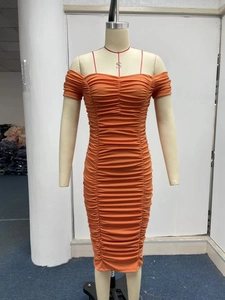 Detail of the elastic shirred fabric on the orange off-shoulder midi dress