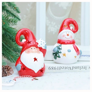 Close-up of ceramic Santa and snowman figurines with hollow star patterns and red details
