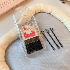 Detailed view of black wavy hairpins in a clear storage box with cute bear card illustration