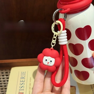 Detailed view of red flower silicone charm with woven lanyard on a stainless steel cup