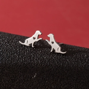 Gros plan de boucles d'oreilles chien en argent avec détail cœur sur cuir noir
