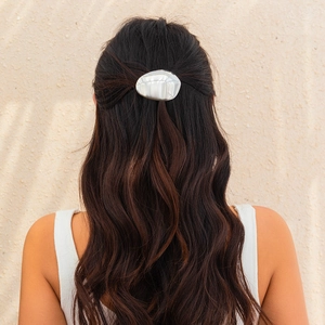 Close-up of pearl texture irregular hair clip worn on elegant half-up hairstyle