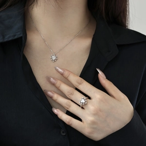 Detail of S925 sterling silver heart ring and necklace with white zircon on a model