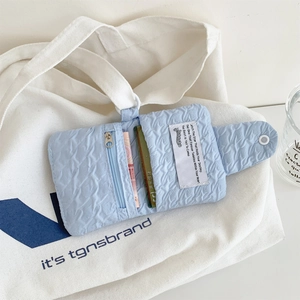Portafoglio minimalista azzurro goffrato con scomparti per carte su tela bianca