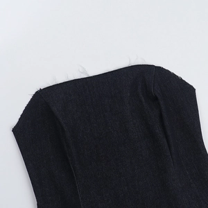 Détail du haut court en denim bleu foncé présentant des bords effilochés et des coutures