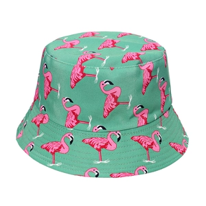 Detailed view of pink flamingo patterns on green canvas reversible bucket hat