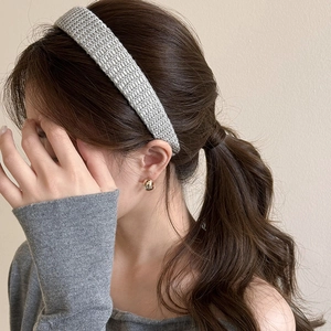 Close-up of grey knitted headband worn by a model with a minimalist autumn fashion style