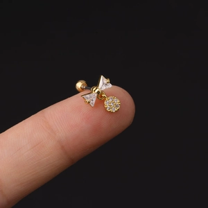 Orecchino a perno a fiocco dorato con zircone e ciondolo tondo sul dito
