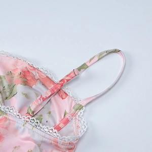 Detailed close-up of pink floral dress with delicate white lace trim and thin straps