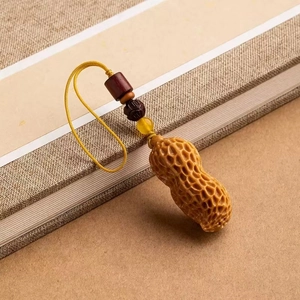 Detailed macro view of a vintage peanut-shaped pendant with intricate texture and beads