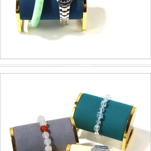 Detail showing soft velvet watch rolls and gold metal frames of a jewelry display stand