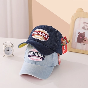 Detailed view of washed denim baseball caps with vintage embroidery and quality stitching
