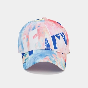 Detail of colorful tie-dye baseball cap with blue and white embroidered letters