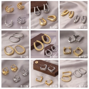 Detailed grid of assorted gold and silver hoop earrings on elegant silk background