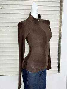 Detail of slim-fit dark brown half-zip sweatshirt with stand collar and thermal fabric